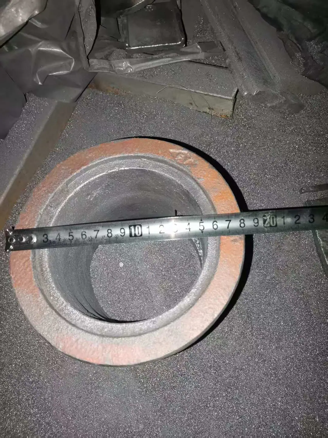 Shot blast control cage top view with tape across the flange for diameter reference